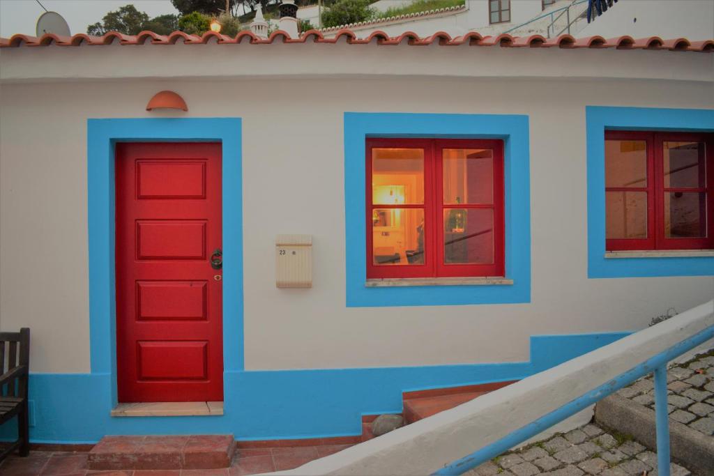 twee rode deuren aan de zijkant van een gebouw bij Hillside 2 Aljezur old town in Aljezur