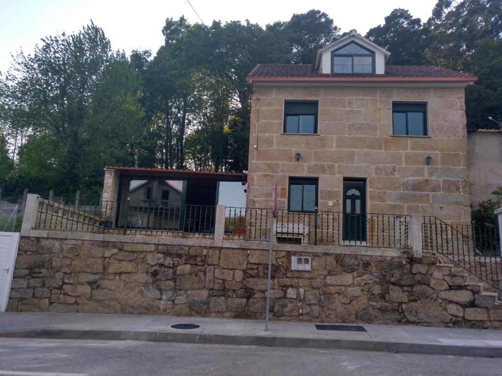 un edificio en una pared de piedra junto a una calle en Casa del Abuelo Ferrol, en Moaña