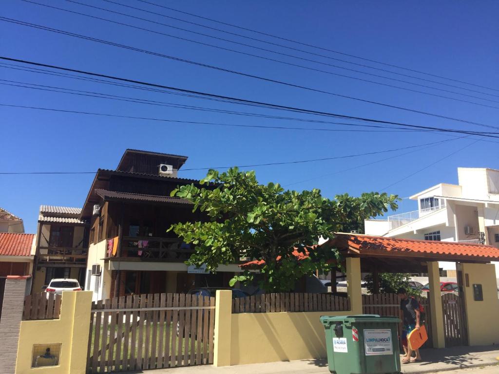 a house with a fence and a tree in front of it at Guarda Flats in Guarda do Embaú