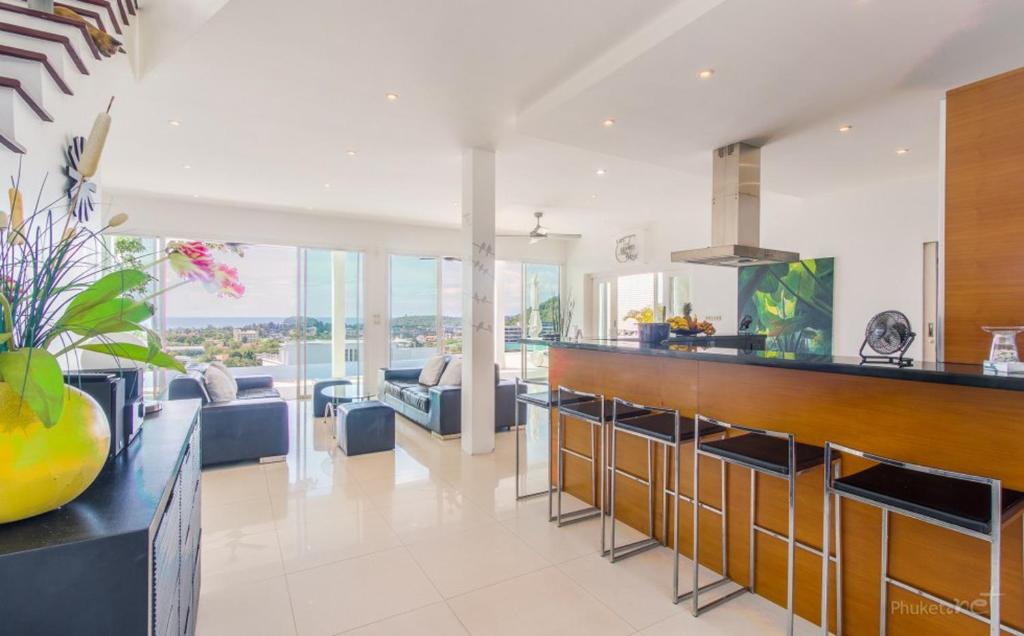 カタビーチにあるVilla Ginborn 5 bedroom Pool Villa with Sea View in Kata Beachのバー付きのキッチン、リビングルームが備わります。