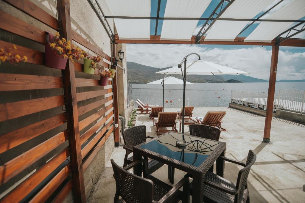 a patio with tables and chairs and a view of the water at Apartment Bojadzi in Ohrid