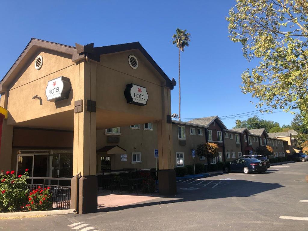 ein Gebäude mit Schildern an der Seite in der Unterkunft Hotel Rose Garden in San Jose