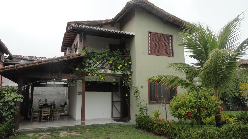 une maison blanche avec des plantes sur son côté dans l'établissement Casa Praia de Taperapuan, Porto Seguro, à Porto Seguro