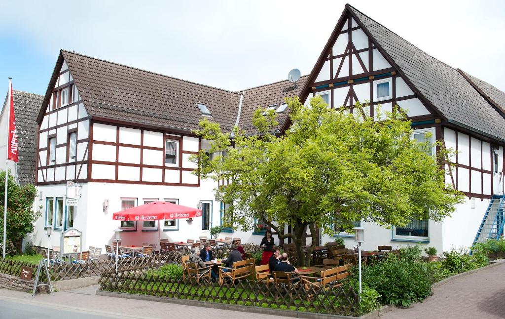 un grupo de personas sentadas en mesas frente a un edificio en Hotel & Restaurant - Gasthaus Brandner, en Trendelburg