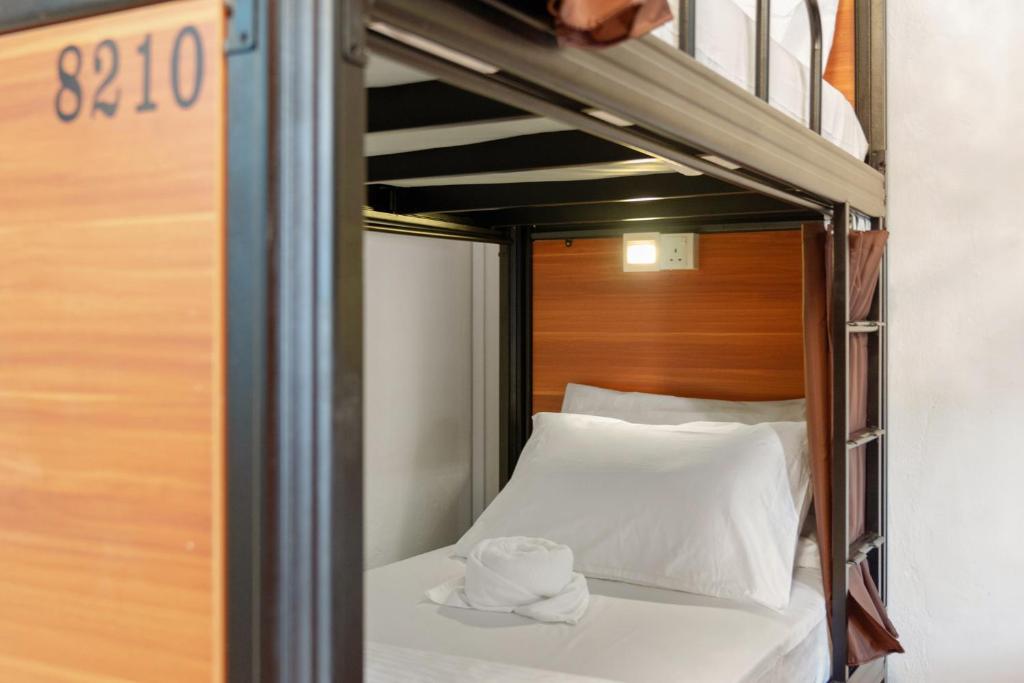 a bunk bed with two towels on top of it at 7 Wonders Hostel at Upper Dickson in Singapore