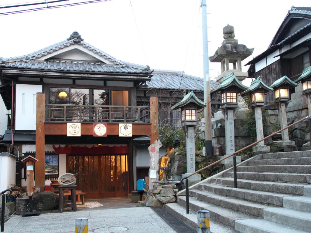 Un bâtiment asiatique avec des escaliers menant à ce bâtiment dans l'établissement Monzen Okagero, à Ikuma