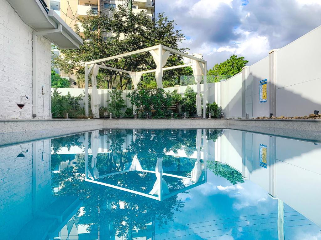 a swimming pool with a white structure reflected in the water at Lamour Holiday Beach House in Gold Coast