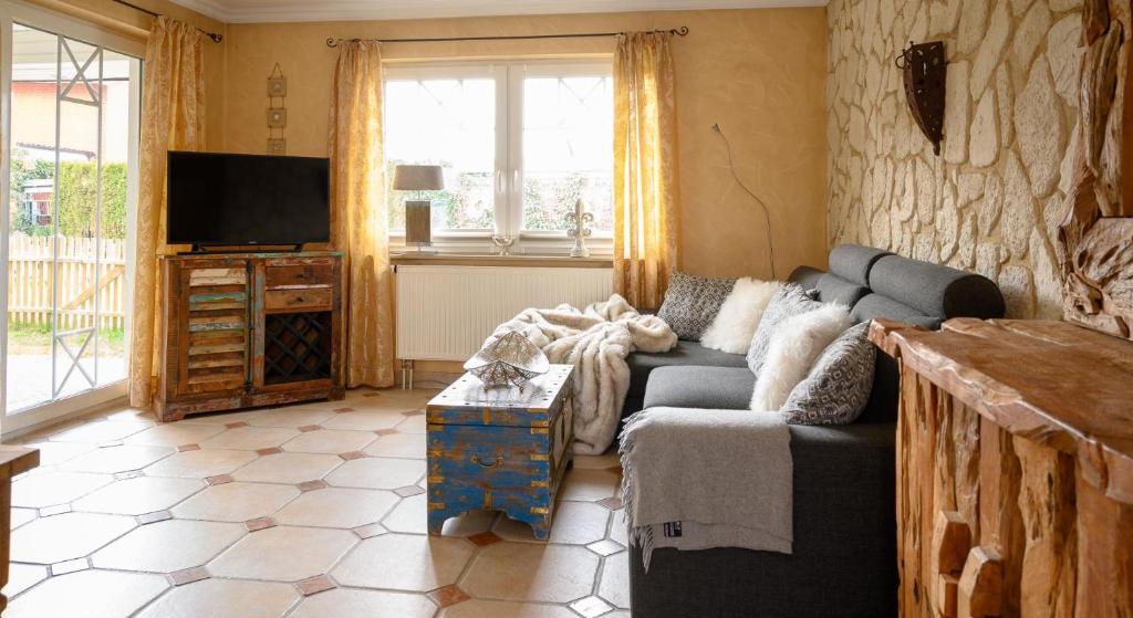 a living room with a couch and a tv at Casa Strandperle in Scharbeutz