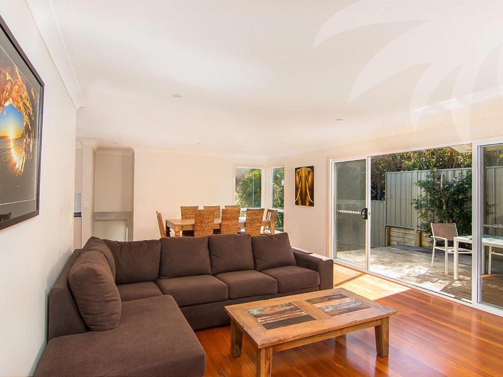 a living room with a couch and a table at Dunes in Blueys Beach