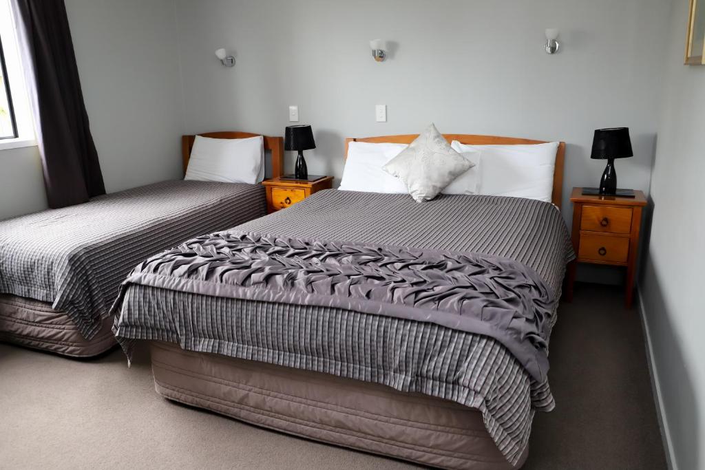 a bedroom with two beds and two night stands at Coronation Park Motels in Ashburton
