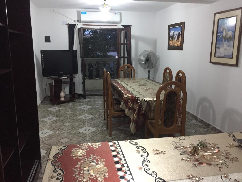 Un comedor con mesa y sillas y un televisor. en Departamento Ciro, en San Salvador de Jujuy