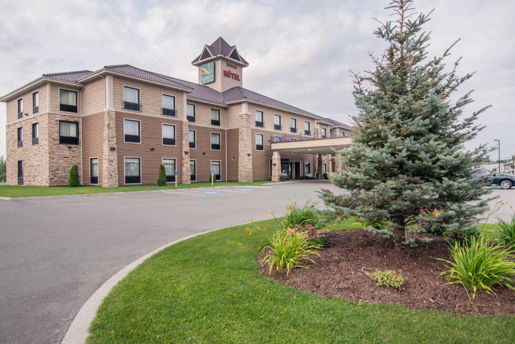 a building with a christmas tree in front of it at Quality Inn & Suites in Val-dʼOr