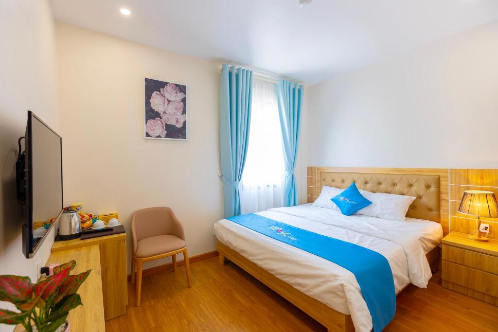 1 dormitorio con 1 cama, 1 silla y 1 ventana en ROSY HẠ LONG HOTEL, en Ha Long