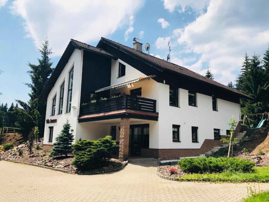 a large white house with a balcony at Vila Jensen in Harrachov