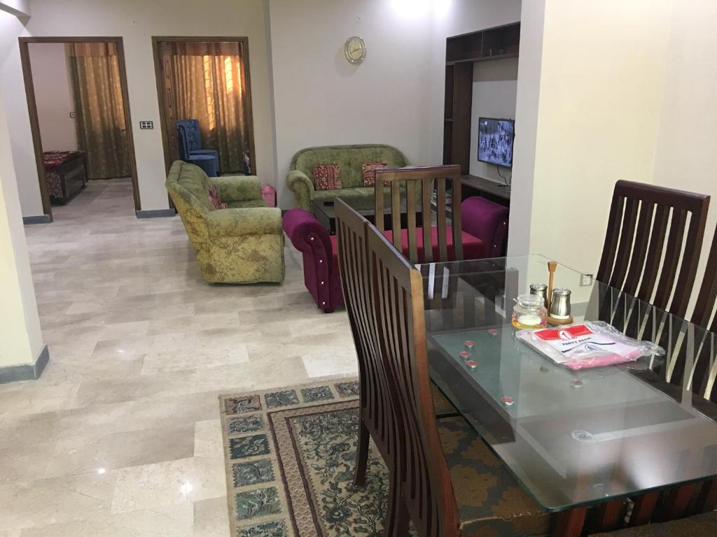 a living room with a glass table and chairs at Spacious Apartment in Johar Town in Lahore