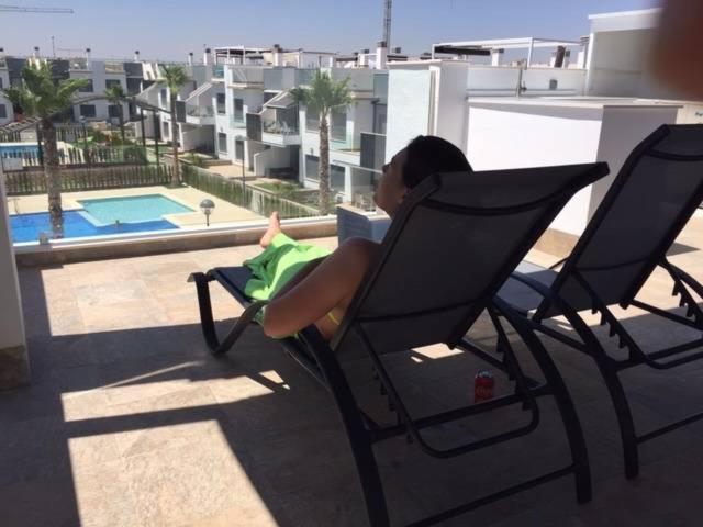 a child sitting in a chair on a balcony at Penthouse Lamar 43.11 in Pilar de la Horadada