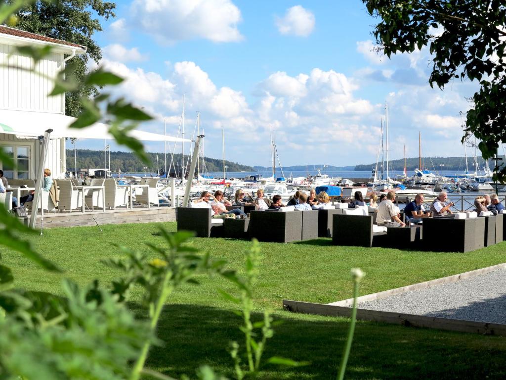 a group of people sitting at tables near a marina at 32 Rum & Kök in Sigtuna