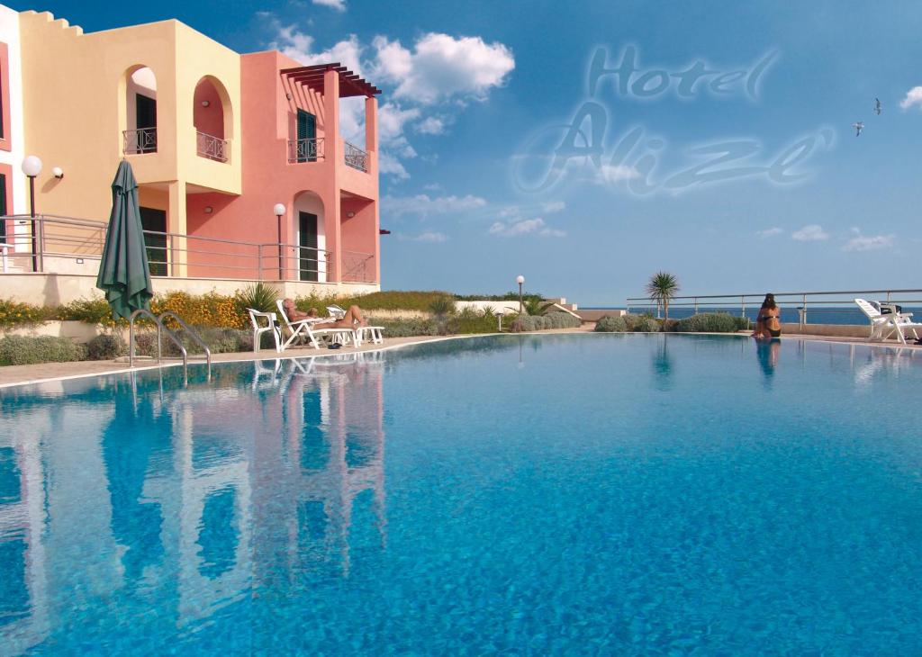 una grande piscina di fronte a un edificio di Hotel Alizé a Santa Cesarea Terme