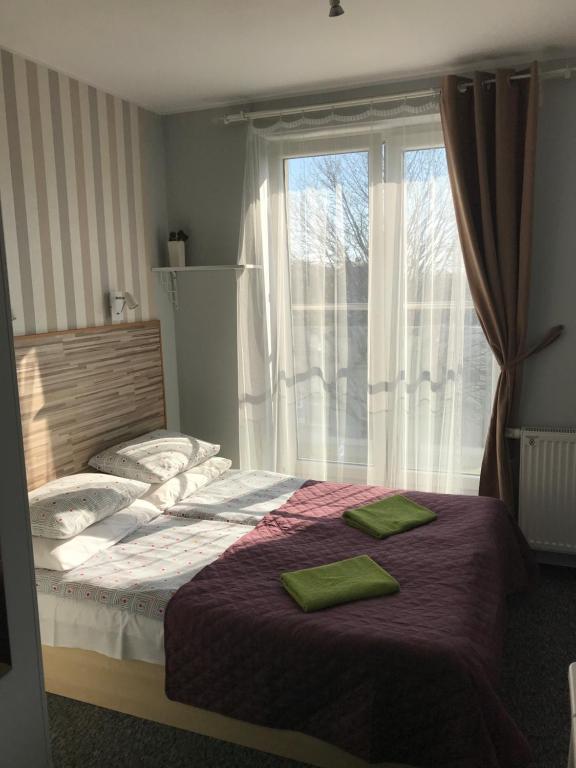 um quarto com uma cama com duas almofadas verdes em Fabryka em Sopot