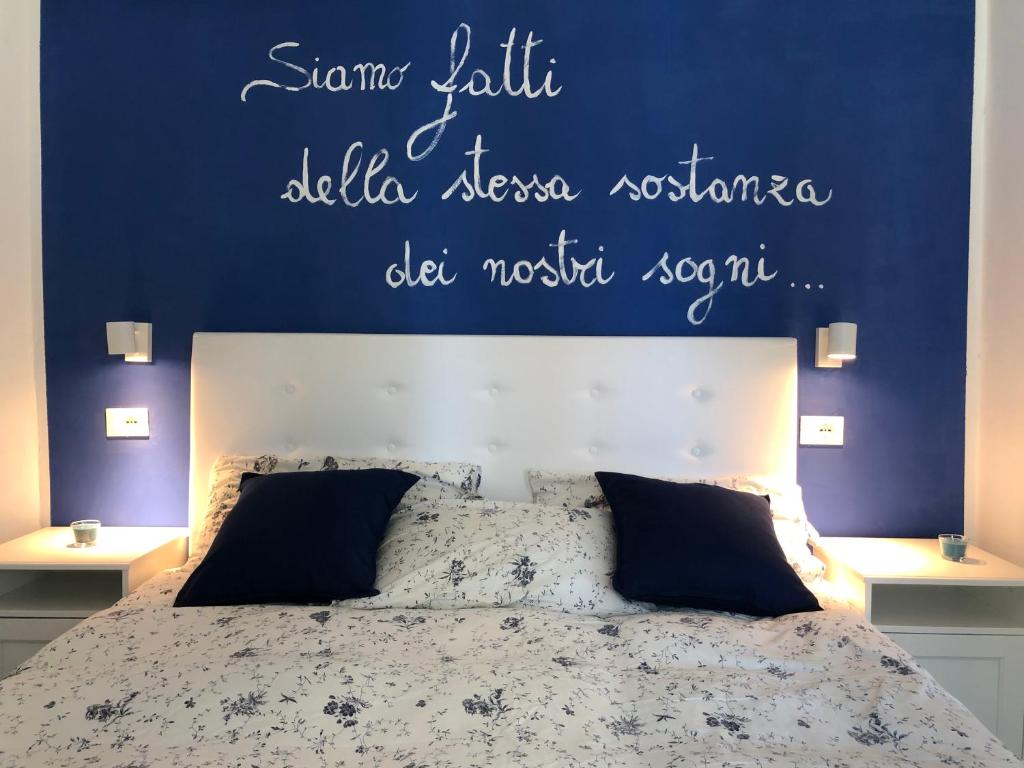 een slaapkamer met een bed met een blauwe muur bij Bed and Breakfast Villa Giovanna in Rimini