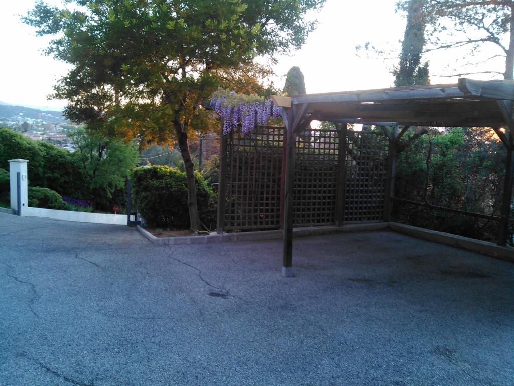 a pergola with a fence with purple flowers at La Villa d&#39;Olivène in Cuers