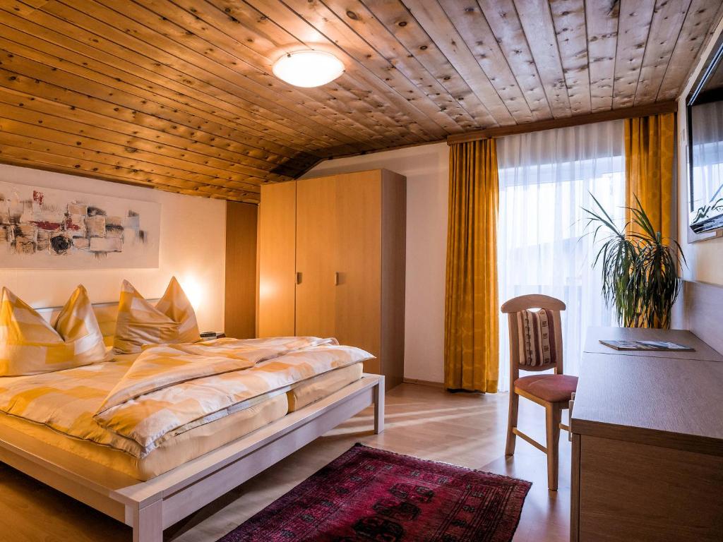 um quarto com uma cama, uma mesa e uma cadeira em Apart Ritzl em Fügen