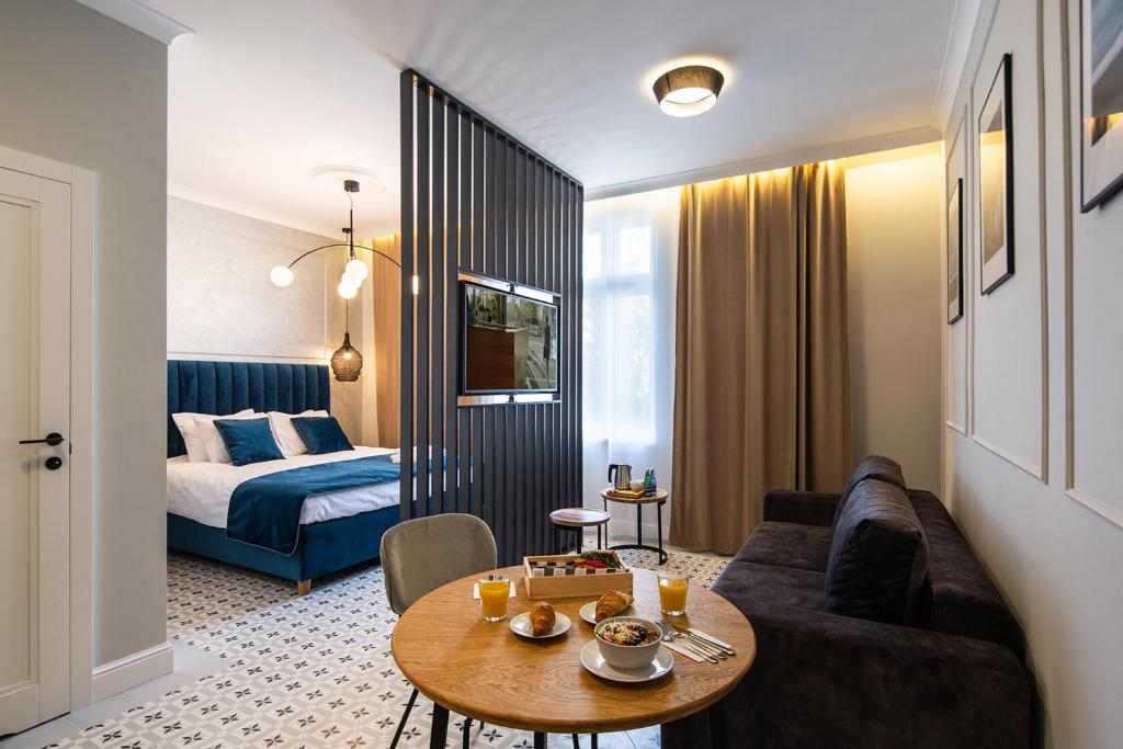 ein Wohnzimmer mit einem Sofa, einem Tisch und einem Bett in der Unterkunft Apartamenty przy Monte Cassino in Sopot