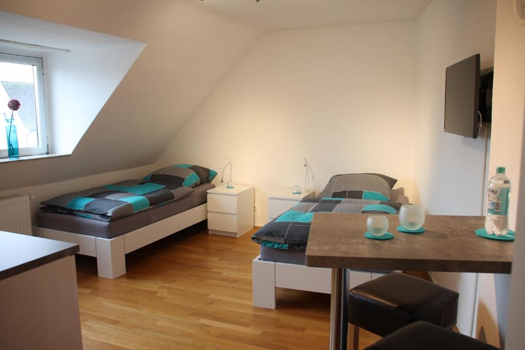 Habitación pequeña con 2 camas y mesa. en Fewo Lorri, en Dorsten