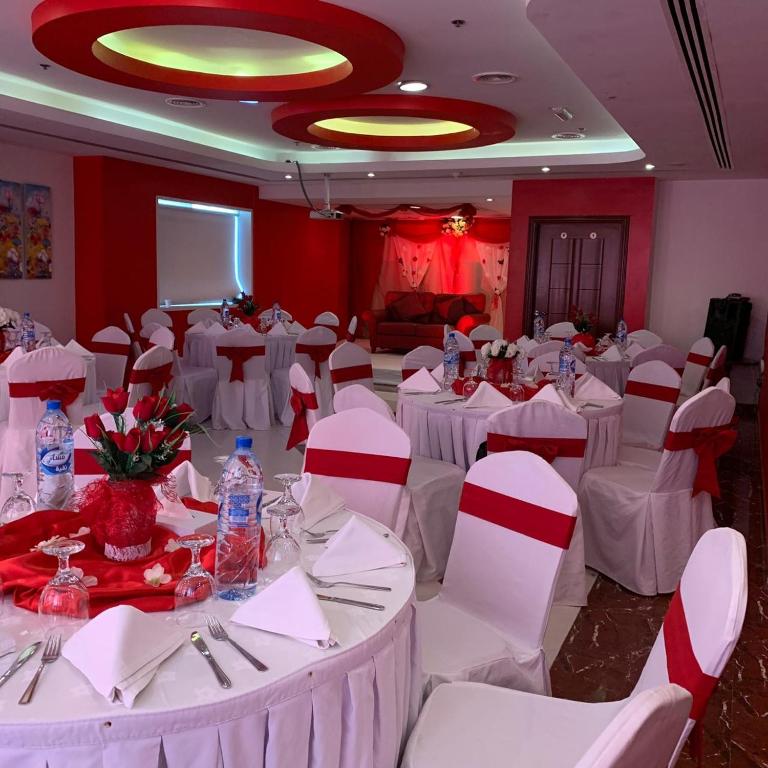 a banquet hall with white tables and white chairs at Hala Inn Hotel Apartments - BAITHANS in Ajman 