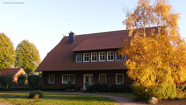 ein braunes Haus mit rotem Dach in der Unterkunft Eschenhof in Syke