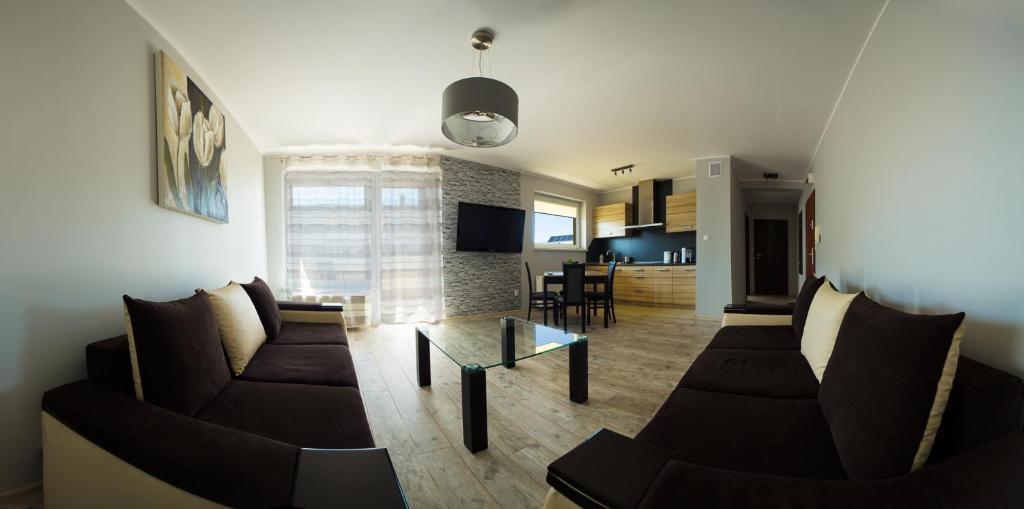 Sala de estar con 2 sofás y mesa en Apartamenty Piła, en Piła
