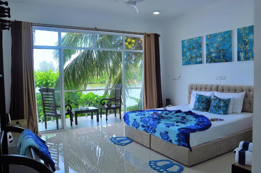 a bedroom with a bed and a large window at Amber House Lanka in Bentota