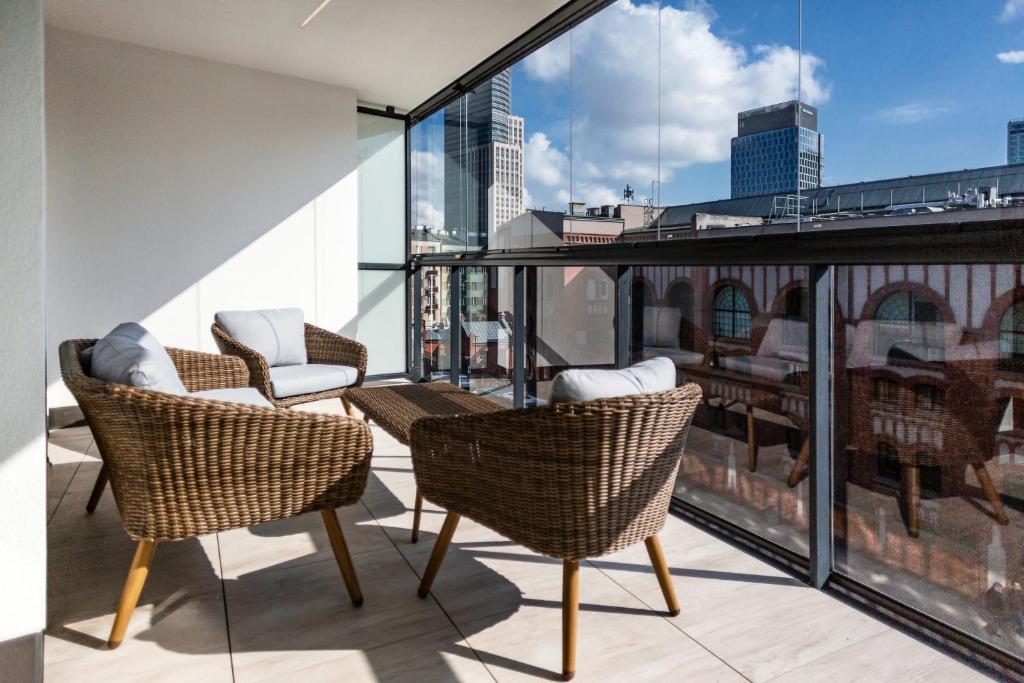 a balcony with chairs and a view of the city at Apartments Warsaw Przyokopowa by Renters in Warsaw