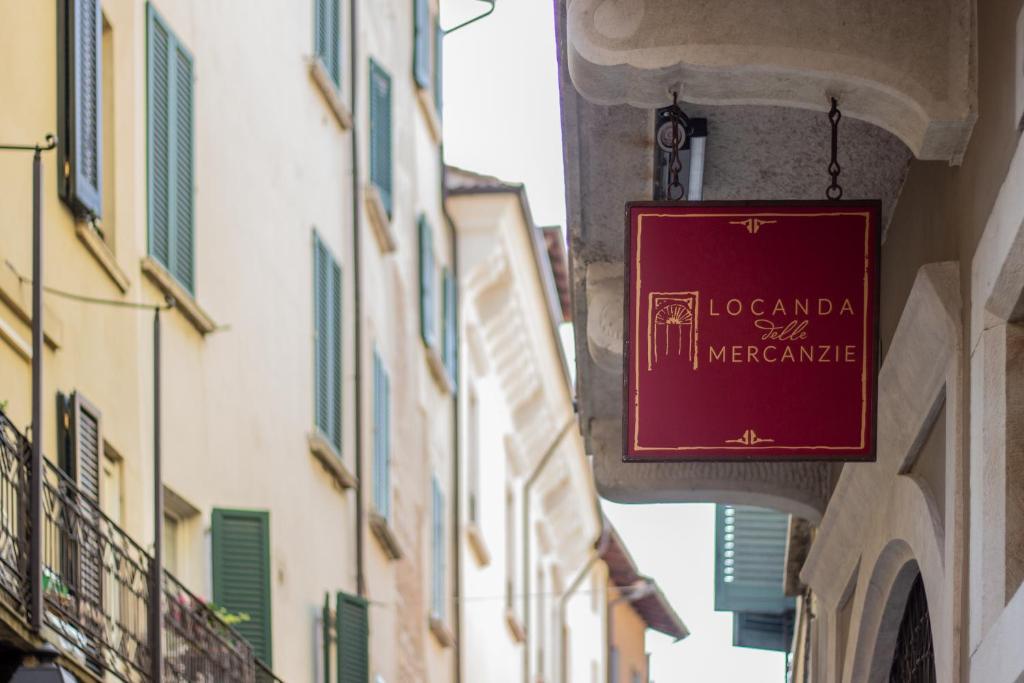 um sinal vermelho pendurado no lado de um edifício em Locanda delle Mercanzie em Brescia