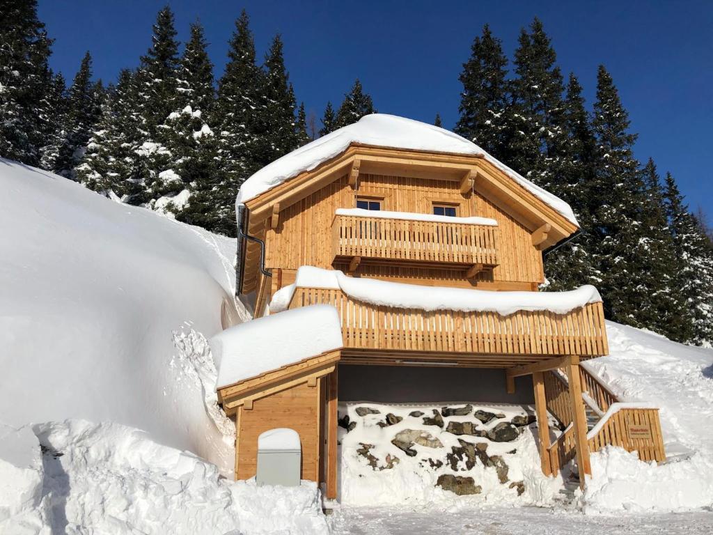 un bâtiment recouvert de neige avec des arbres en arrière-plan dans l'établissement Mankerl Hütte Lachtal, à Lachtal