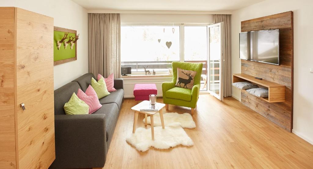 a living room with a gray couch and a green chair at Ferienwohnung Kraus in Tiefenbach bei Oberstdorf