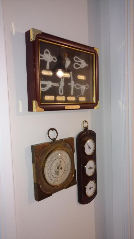 a clock on a wall with two candles on it at Jurnieku nams in Liepāja