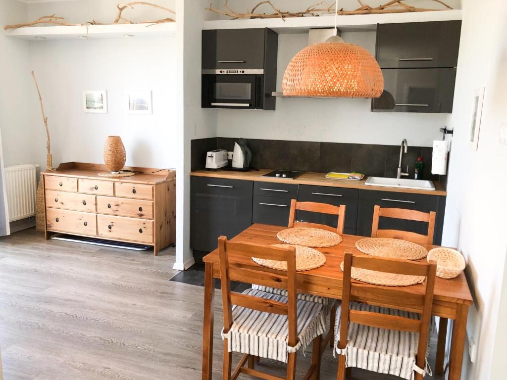 een keuken met een houten tafel en een aantal stoelen bij Widok in Jastrzębia Góra