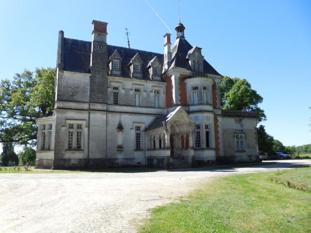 Château de la Redortière في Lézignac-Durand: منزل قديم أمامه ميدان عشبي