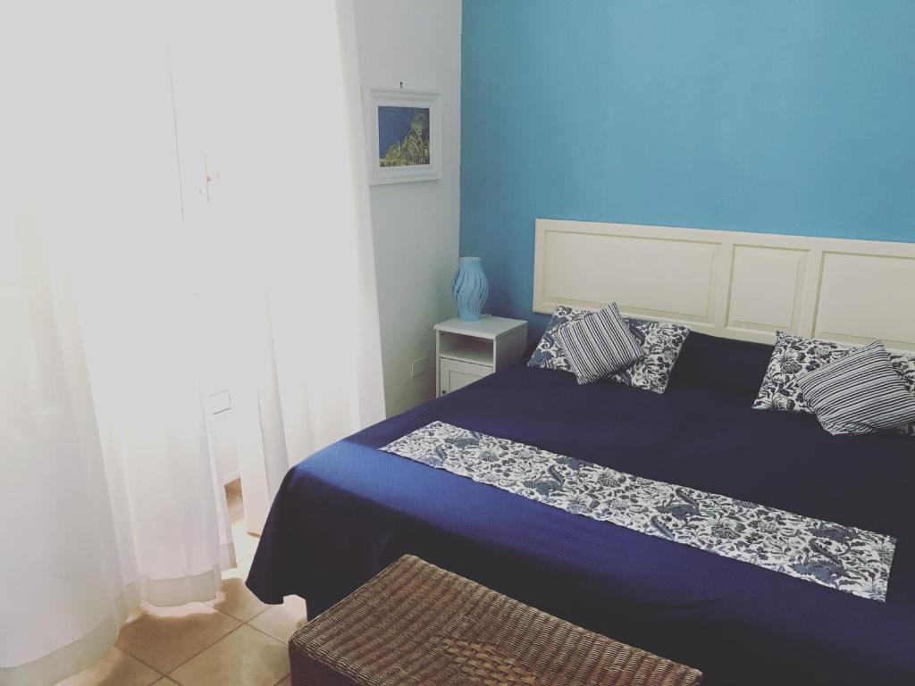 a blue bedroom with a bed and a blue wall at Il Miraggio in Fregene