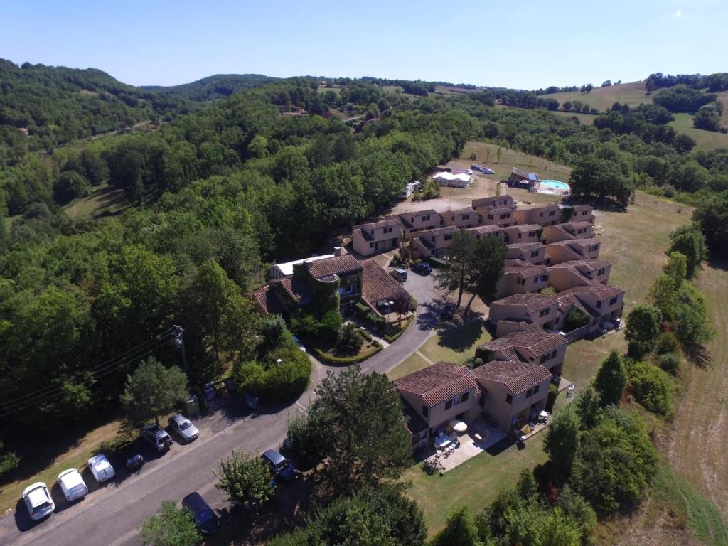 an aerial view of a house with cars parked in front at Village Bord de Ciel in Caylus
