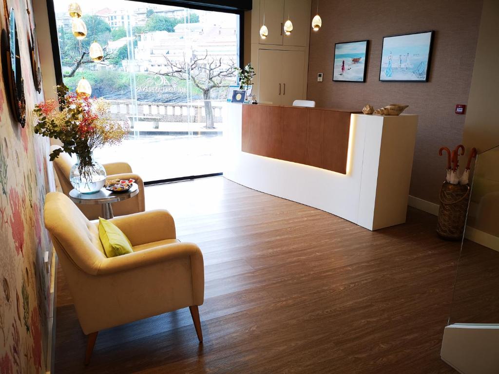 a waiting room with a chair and a reception desk at Hotel Boutique Aquaria Caneliñas in Portonovo
