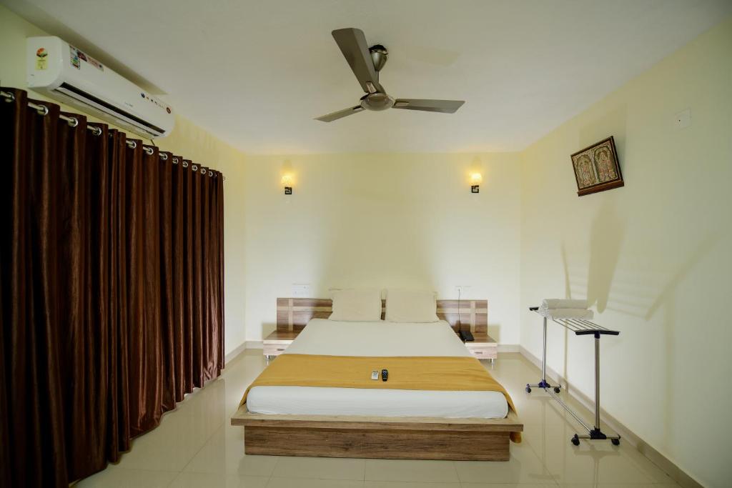 a bedroom with a bed and a ceiling fan at Shesha KUTEERA in Subrahmanya