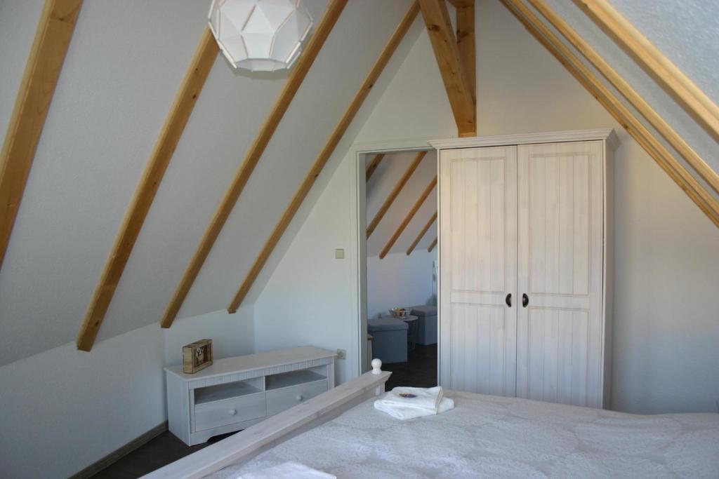 a room with a bed and a ceiling with wooden beams at Apartment Jakobsweg GbR in Pettstädt