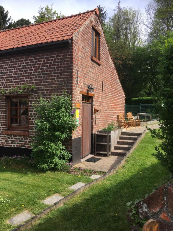 ein Backsteinhaus mit einer Tür und einer Terrasse in der Unterkunft 't Huizeke in Asse