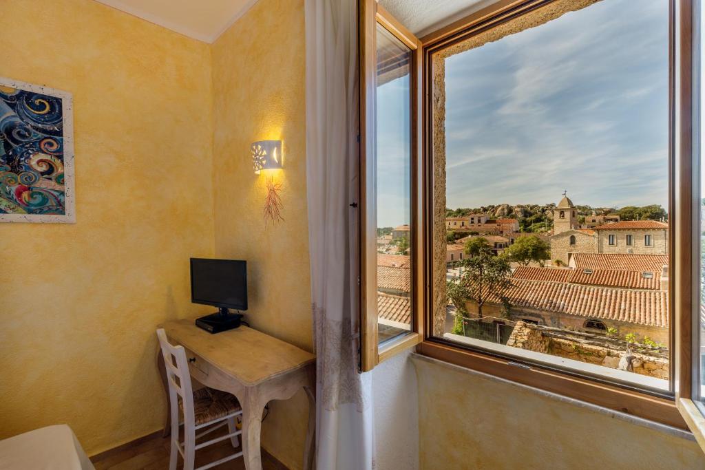 a room with a desk and a window with a view at Palazzo Beddoro in San Pantaleo