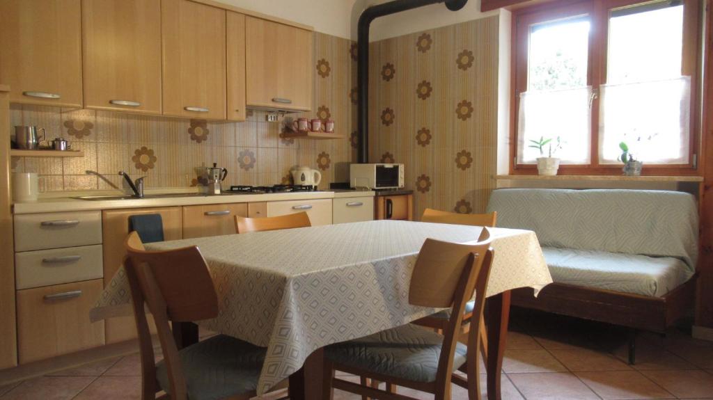 Brissogne的住宿－Maison Fiou，厨房配有桌子、椅子和桌子,厨房