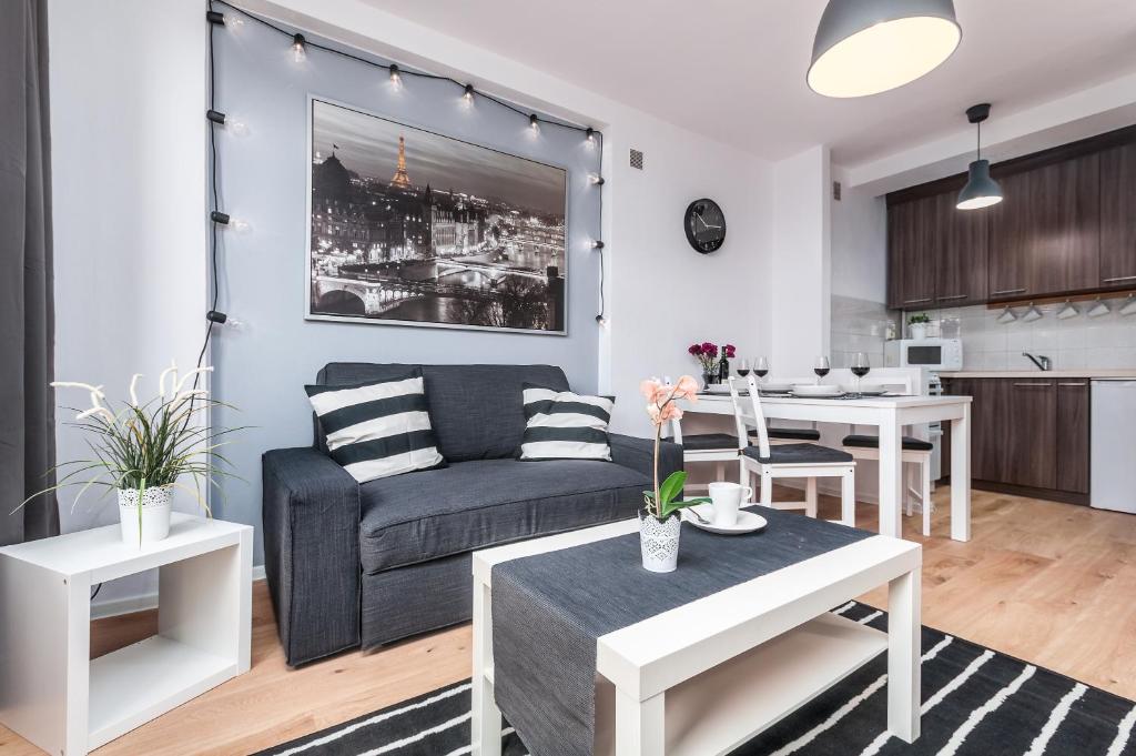 a living room with a couch and a table at Apartments Dexter Warsaw by Renters in Warsaw