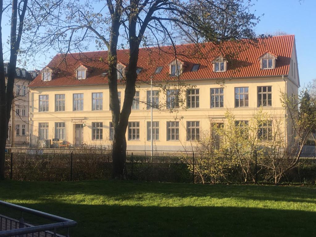 een groot wit gebouw met een rood dak bij Apartment Schloss Benrath in Greifswald