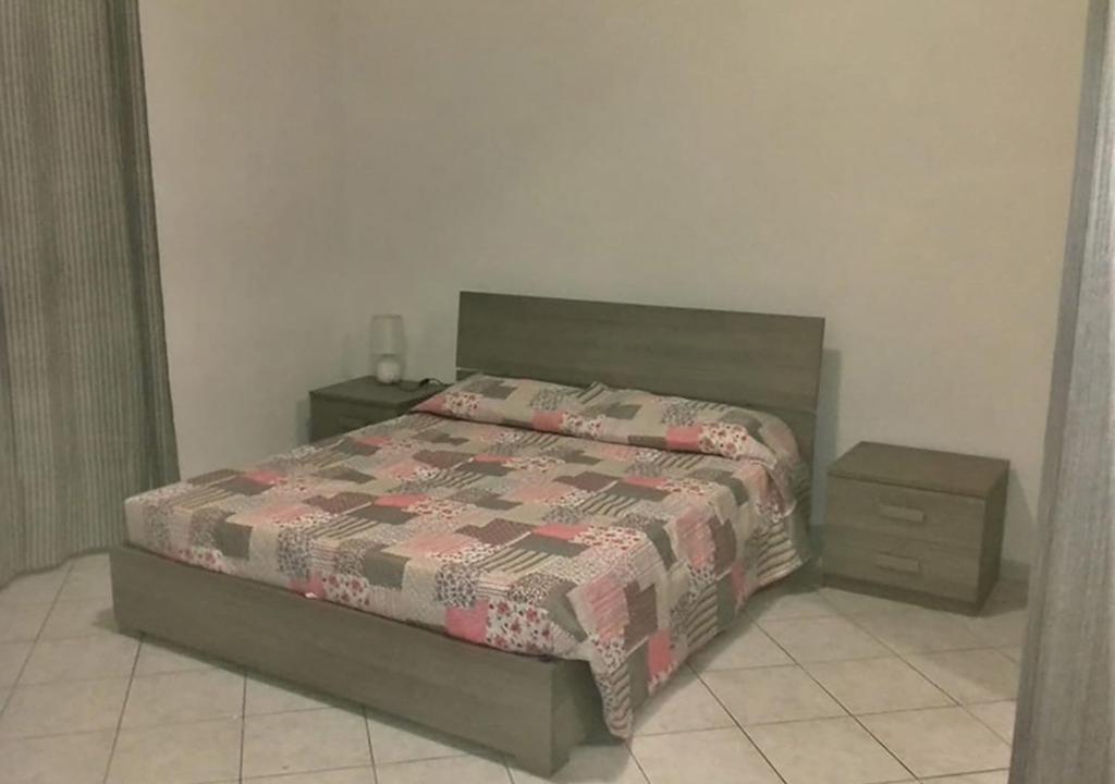 a bedroom with a bed and two night stands at GALLURAS B&B in Olbia